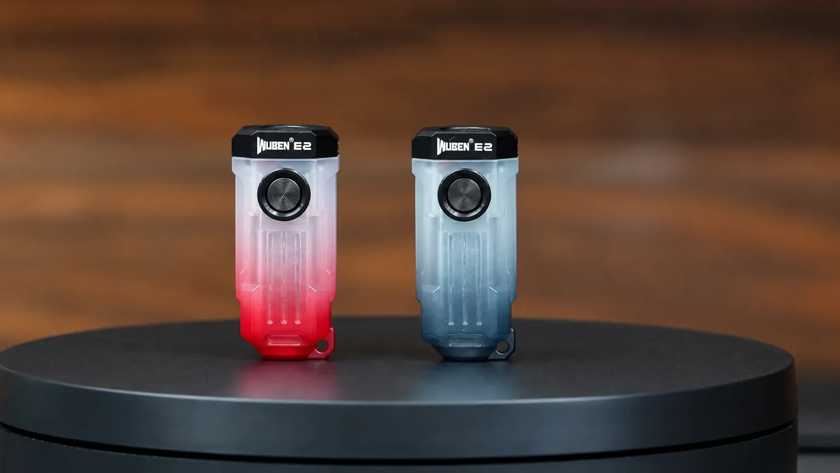 撮影台に並べた赤と黒のWUBEN E2。半透明の小さなボディと前面スイッチ